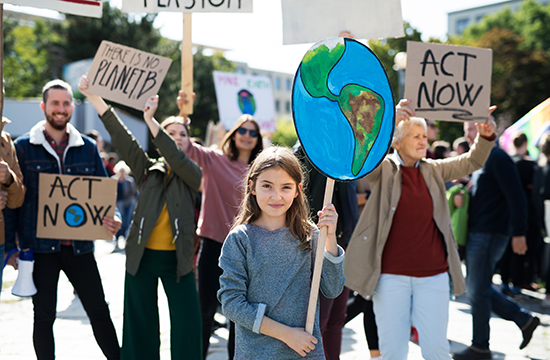 People and children with placards and posters on global strike for climate
