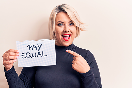 Beautiful Plus Size Woman Asking For Equality Economy Holding Paper that says Pay Equal and Fair Wages